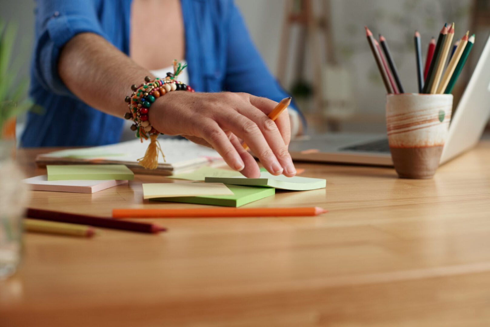 Hand reaching for sticky notes on desk